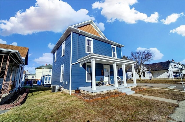 view of front facade with a porch, a front yard, and central AC unit