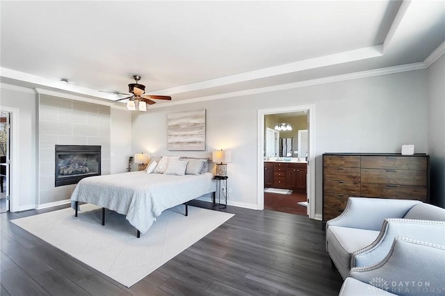 bedroom featuring ornamental molding, dark wood-style flooring, a raised ceiling, and baseboards
