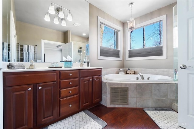 bathroom featuring vanity, hardwood / wood-style floors, and plus walk in shower