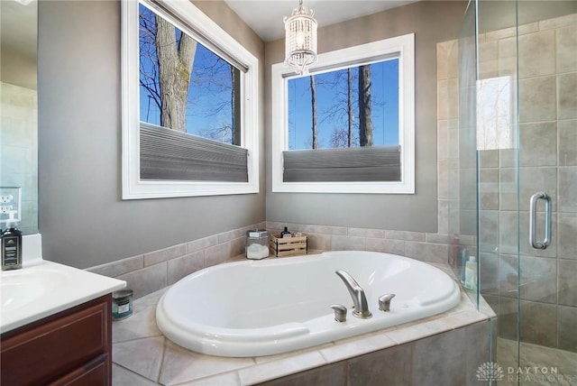 bathroom featuring vanity, a notable chandelier, and independent shower and bath