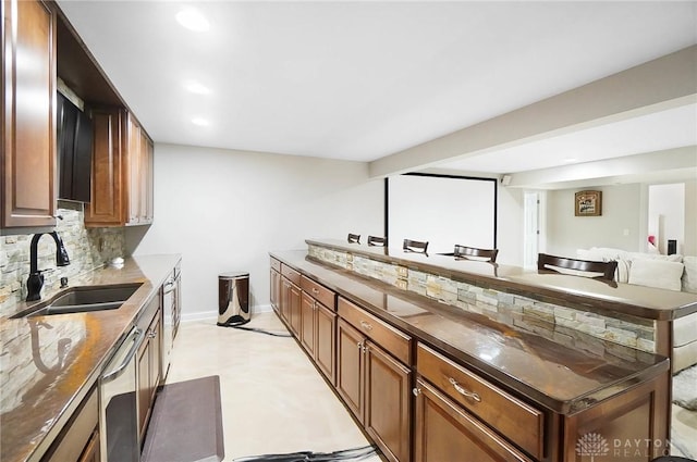 kitchen with washer / clothes dryer, dishwasher, sink, and decorative backsplash