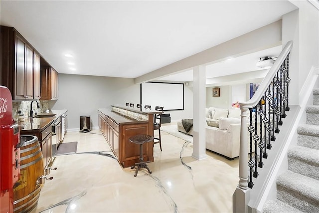 kitchen with a kitchen island, sink, a breakfast bar area, and backsplash