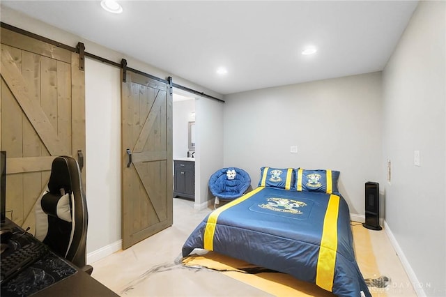 bedroom featuring a barn door and ensuite bath