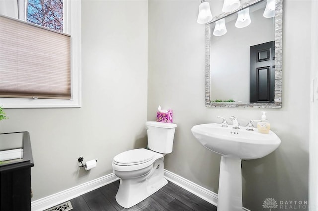 bathroom with hardwood / wood-style flooring and toilet