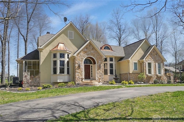 craftsman house with a front yard, stone siding, stucco siding, and a shingled roof