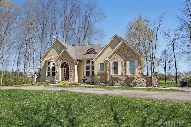 craftsman inspired home featuring a front lawn, stone siding, and stucco siding