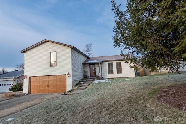 tri-level home with a garage and a front lawn