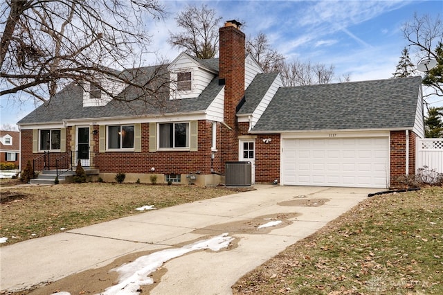 new england style home featuring a garage, a front yard, and central AC unit