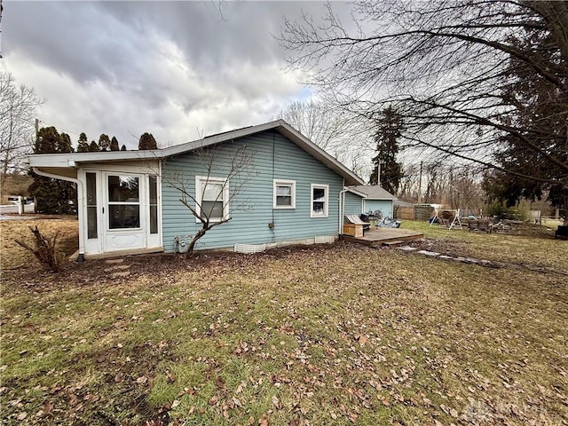 view of property exterior featuring a wooden deck and a lawn