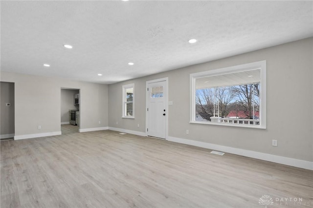 interior space featuring a textured ceiling, light hardwood / wood-style flooring, and a wealth of natural light