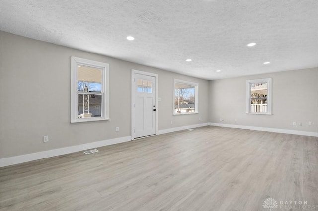 interior space featuring light hardwood / wood-style flooring and a textured ceiling