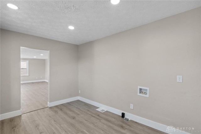 interior space with a textured ceiling and light hardwood / wood-style floors