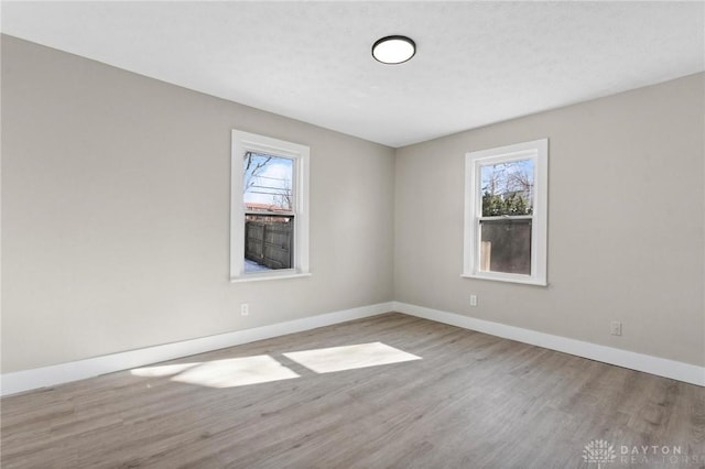 empty room with a healthy amount of sunlight and light hardwood / wood-style floors