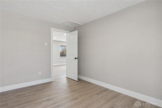 empty room featuring a textured ceiling and light wood-type flooring