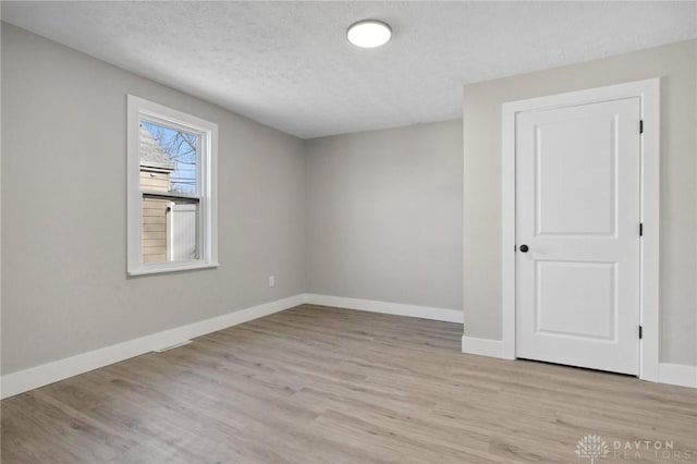 empty room featuring light hardwood / wood-style floors and a textured ceiling