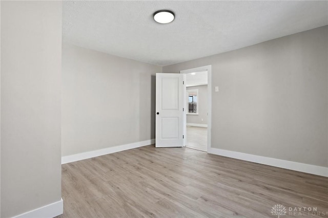 spare room with light hardwood / wood-style flooring and a textured ceiling