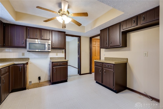 kitchen featuring dark brown cabinetry, a textured ceiling, and backsplash