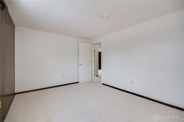 carpeted spare room featuring a textured ceiling