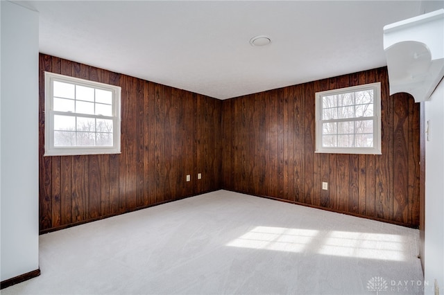 carpeted spare room with wooden walls