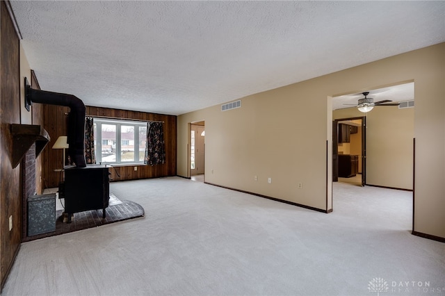 living room with ceiling fan, light carpet, and a textured ceiling