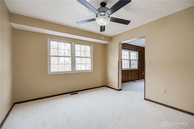 carpeted spare room with ceiling fan