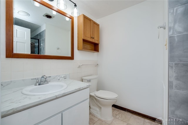 bathroom featuring vanity, a shower, tile walls, and toilet