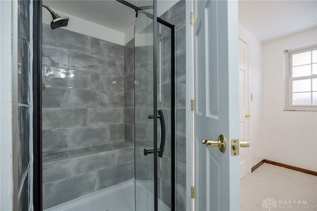 bathroom with a textured ceiling and a shower with shower door