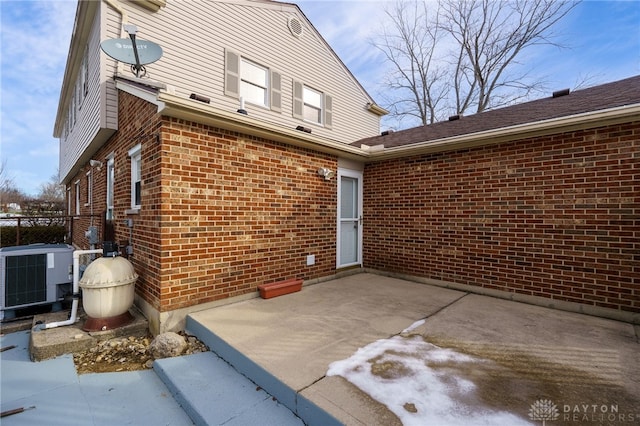 doorway to property with central AC unit and a patio area