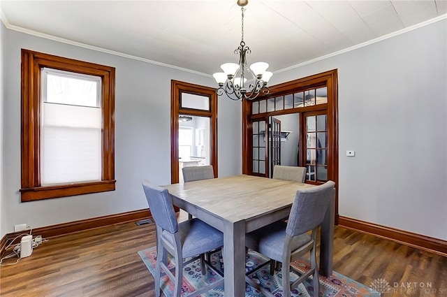 dining room featuring ornamental molding, a notable chandelier, and dark hardwood / wood-style flooring