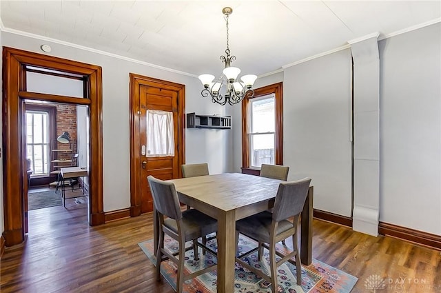 dining room with an inviting chandelier, a healthy amount of sunlight, ornamental molding, and dark hardwood / wood-style flooring