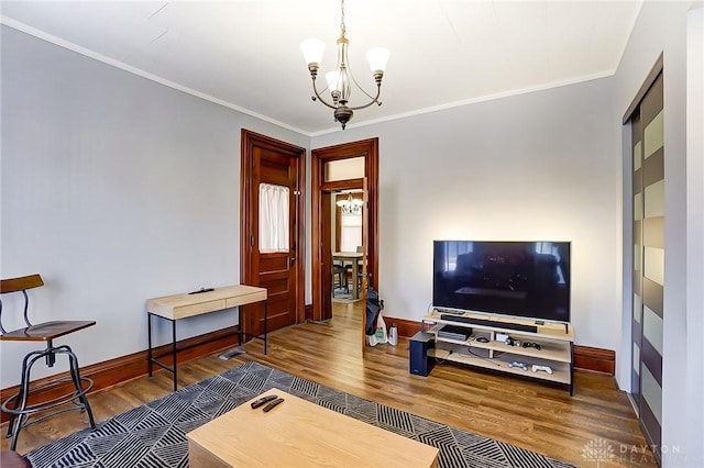 living room featuring dark hardwood / wood-style flooring, a notable chandelier, and ornamental molding