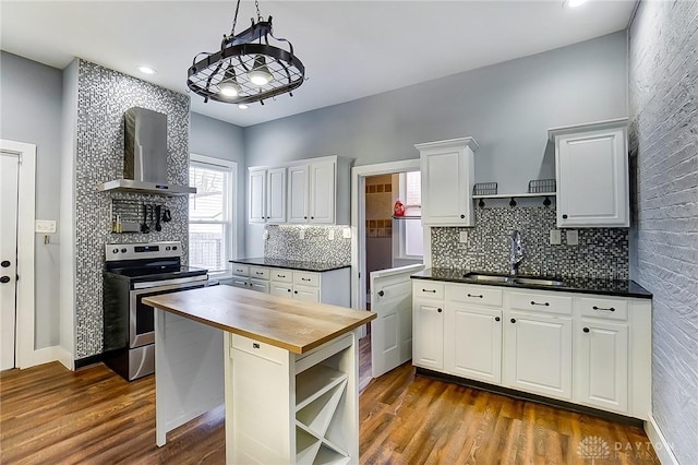 kitchen featuring stainless steel electric range, wooden counters, white cabinets, dark hardwood / wood-style flooring, and wall chimney exhaust hood