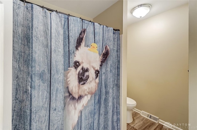 bathroom featuring hardwood / wood-style flooring and toilet