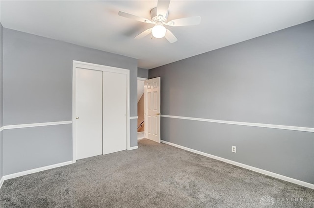 unfurnished bedroom featuring ceiling fan, a closet, and carpet