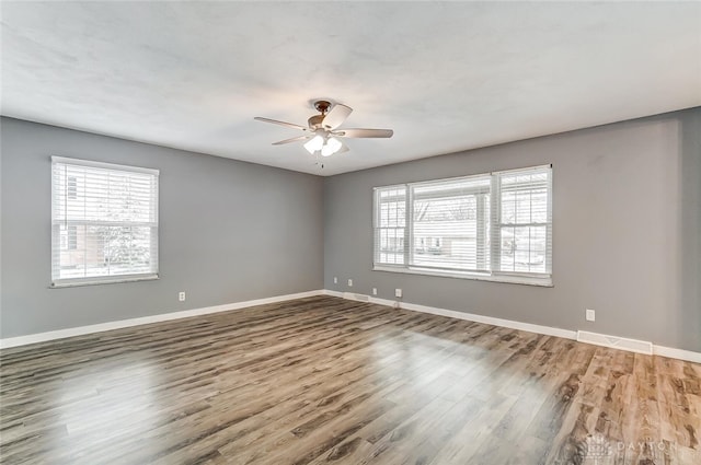 spare room with hardwood / wood-style flooring, plenty of natural light, and ceiling fan