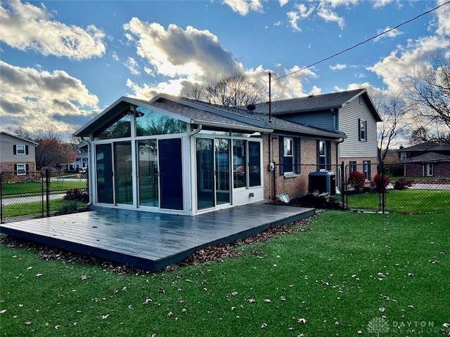 rear view of house with central AC, a lawn, a sunroom, and a deck