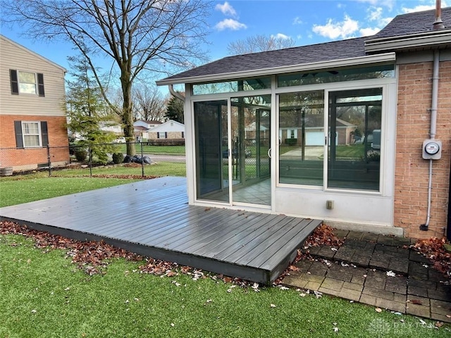 deck featuring a yard and a sunroom