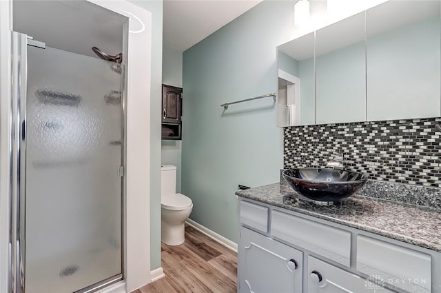 bathroom featuring vanity, an enclosed shower, decorative backsplash, and wood-type flooring