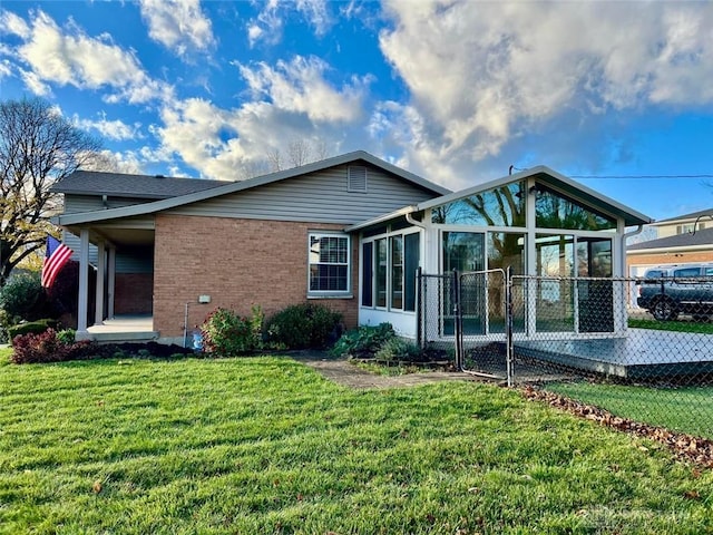 back of property featuring a sunroom and a yard