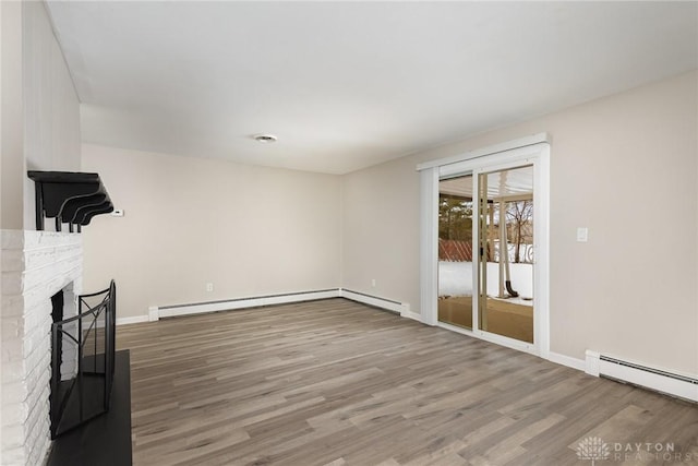 unfurnished living room featuring a baseboard radiator, wood-type flooring, and a brick fireplace