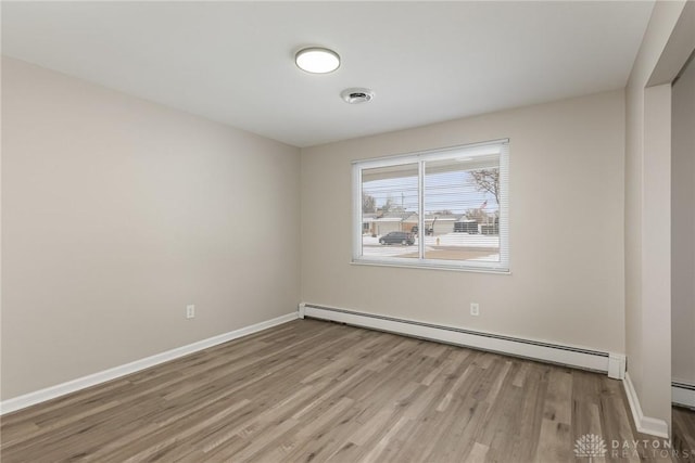 spare room with light hardwood / wood-style floors and a baseboard heating unit