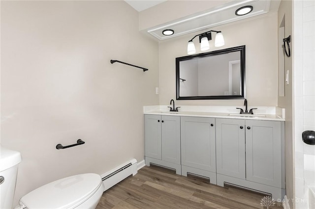 bathroom with hardwood / wood-style flooring, a baseboard radiator, vanity, and toilet