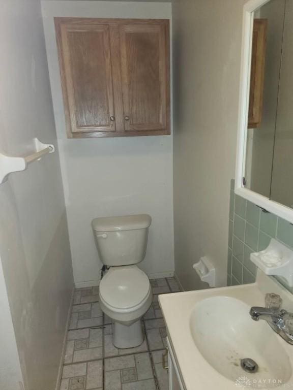 bathroom with tasteful backsplash, vanity, and toilet