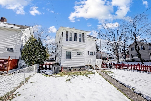 snow covered property featuring central AC