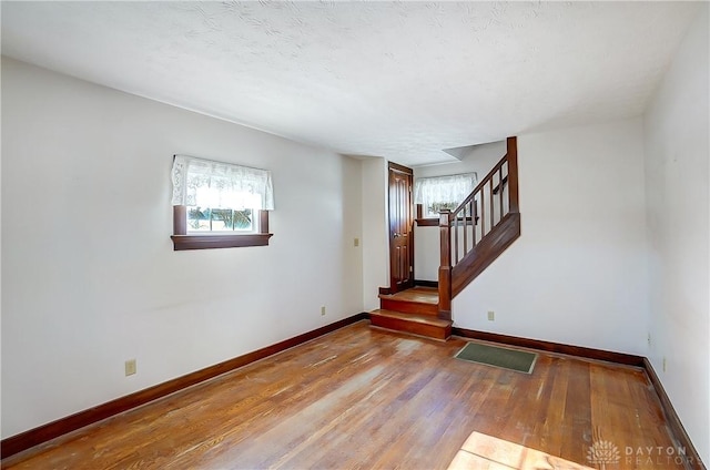 empty room featuring wood-type flooring and a textured ceiling