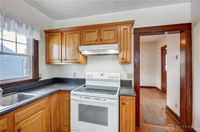 kitchen with white electric range, sink, light hardwood / wood-style flooring, and a textured ceiling