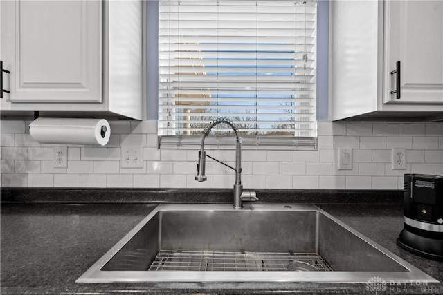 kitchen with white cabinetry, sink, and backsplash