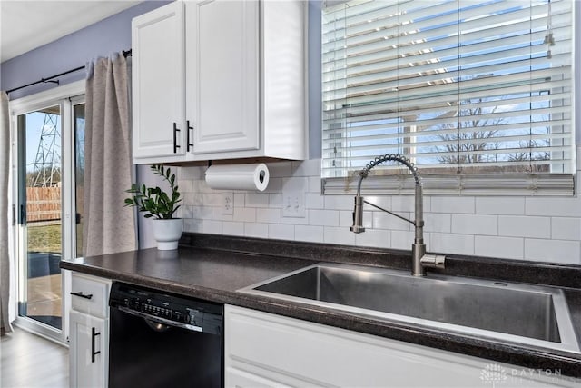 kitchen featuring tasteful backsplash, dishwasher, sink, and white cabinets