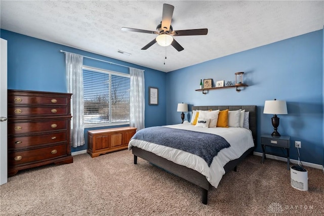 carpeted bedroom featuring ceiling fan and a textured ceiling