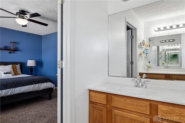 bathroom with vanity, ceiling fan, and a textured ceiling